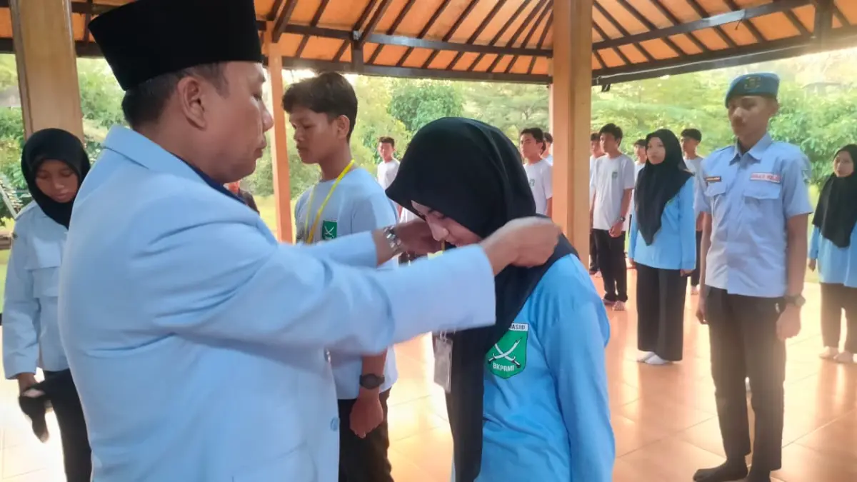 H. Jamaludin selaku Ketua Umum DPW BKPRMI NTB mengalungkan tanda kepesertaan secara simbolis kepada perwakilan peserta saat pembukaan Pelatihan Tanggap Bencana Brigade Masjid BKPRMI NTB di Bumi Perkemahan Terenggani, Desa Karang Bayan, Kecamatan Lingsar, Senin (22/6).