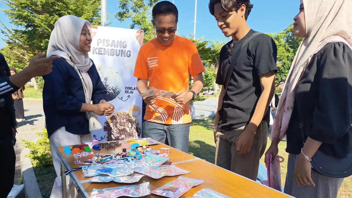 JUAL PRODUK: Mahasiswa Universitas Hamzanwadi Pancor menawarkan kerajinan gantungan kunci yang dibuat dari tutup botol bekas kepada Sekda Lotim di acara car free day (CFD).