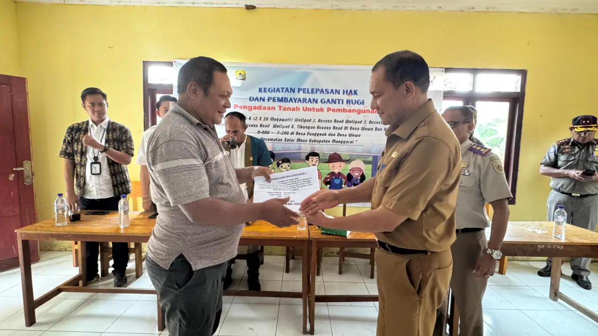 Asisten II Setda Kabupaten Manggarai Petrus Caelestinus Masangkat (kanan) secara simbolis menyerahkan pembayaran ganti rugi kepada masyarakat yang berhak dalam kegiatan pengadaan tanah pembangunan akses jalan PLTP Ulumbu Unit 5.