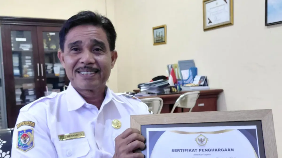 PROGRES TERTINGGI: Heryanto menunjukkan piagam penghargaan dari BPK.