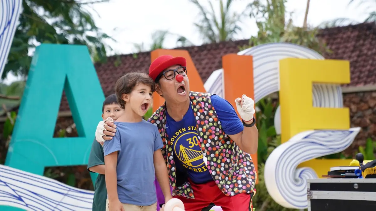 LIBUR SEKOLAH: Seorang badut sedang bermain dengan anak-anak di area Kuta Lane The Mandalika, Kuta, Pujut, Loteng, Minggu (28/6). (Dewi/Lombok Post) 