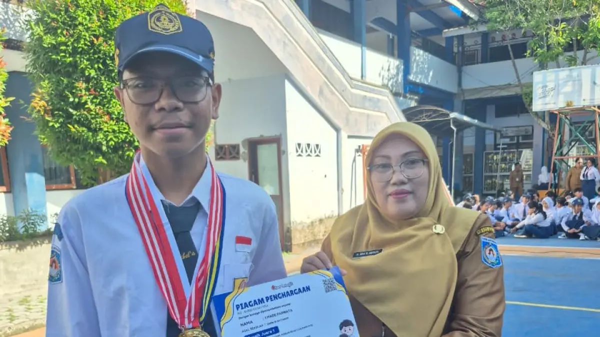 PRESTASI: I Made Parwata, siswa SMPN 15 Mataram yang meraih medali emas Olimpiade Sains NTB menerima penghargaan dari Wakil Kepala Bidang Kurikulum G.A. Suartini Astuti usai apel di halaman sekolah setempat, belum lama ini.

