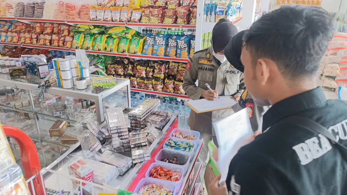RAZIA: Satpol-pp Lotim saat melakukan operasi rokok ilegal di salh satu toko di Lotim. 