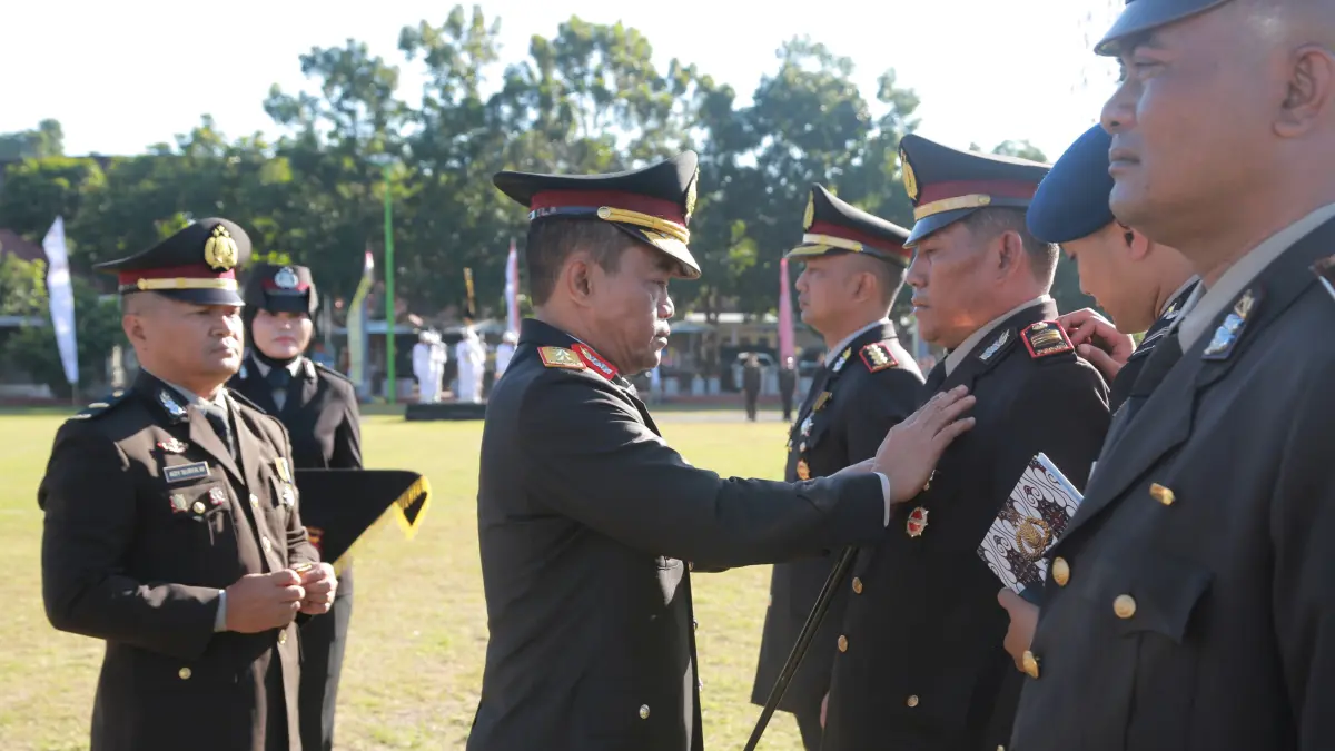 Kapolda NTB Irjen Pol. Kalingga Rendra Raharja memasang tanda penghargaan pada anggota Polri dalam upacara peringatan Hari Bhayangkara ke-80 di Lapangan Bhara Daksa.