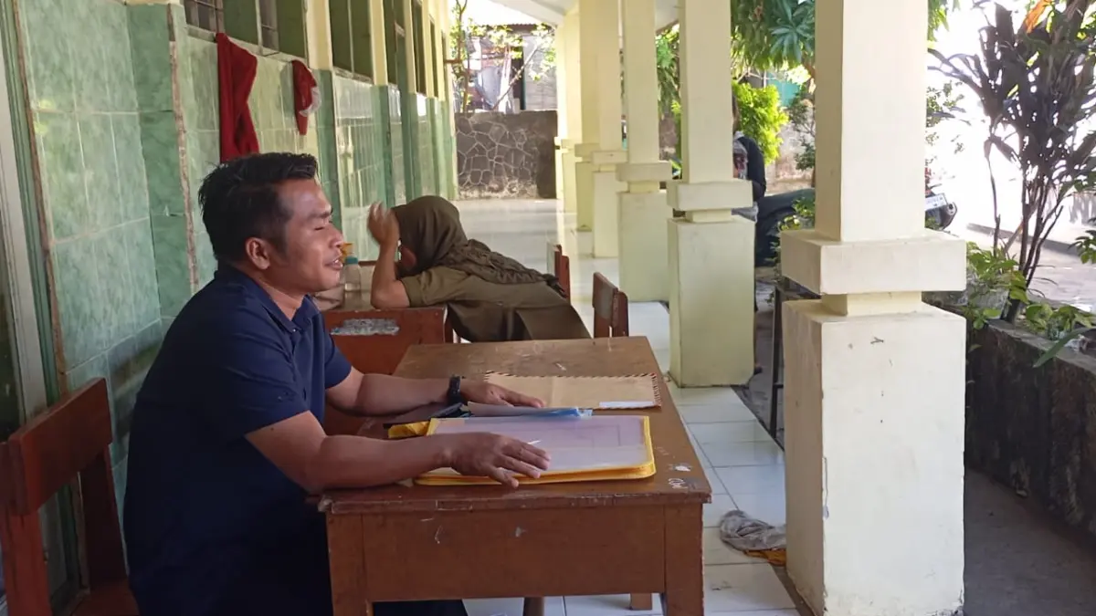 TUNGGU PENDAFTAR: Guru SDN 12 Mataram menunggu orang tua yang mendaftarkan anaknya di sekolah setempat, Selasa (30/6).