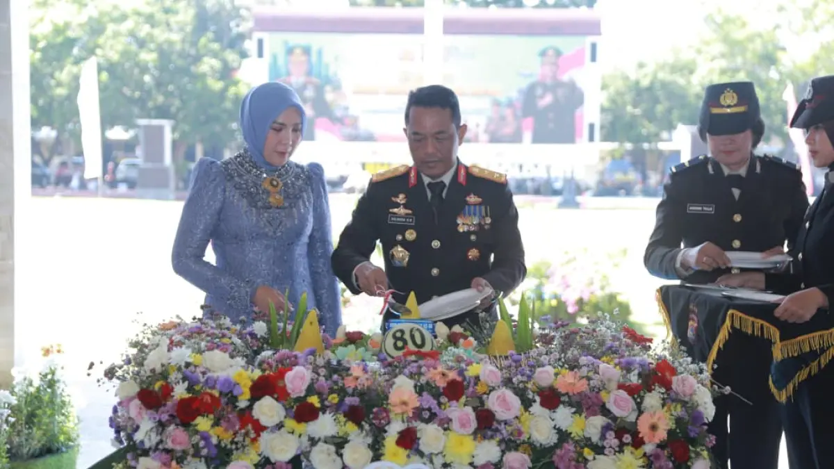 HUT POLRI: Kapolda NTB Irjen Pol Kalingga Rendra Raharja didampingi istri memotong tumpeng saat HUT Bhayangkara Polda NTB, Rabu (1/7). (HARLI/LOMBOK POST)