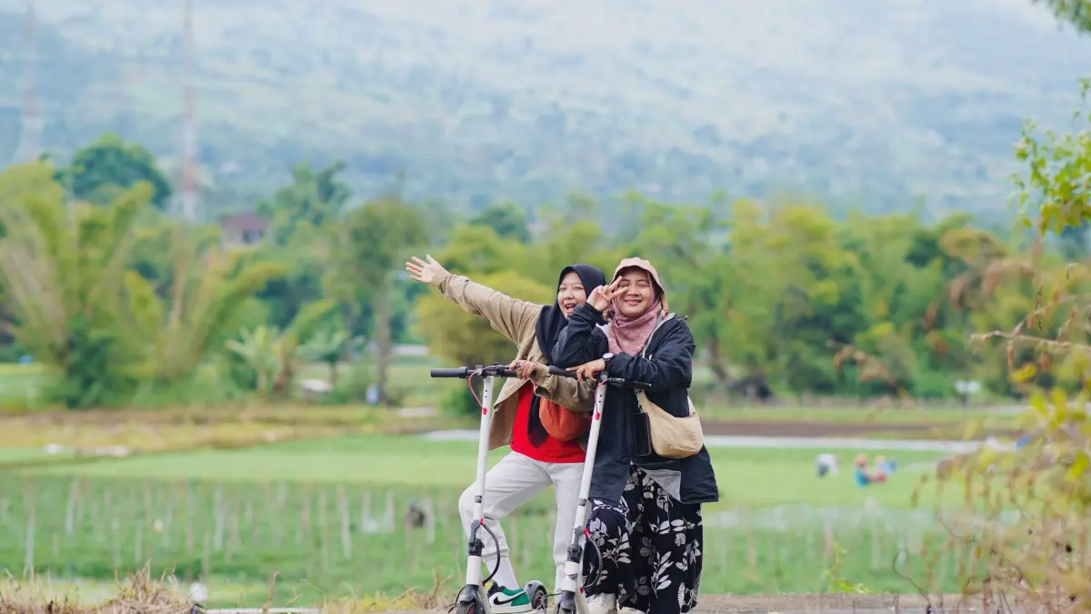 LIBURAN KELUARGA: Dua orang wanita menikmati pemandangan alam Gunung Rinjani menggunakan sekuter di jalan raya Desa Sembalun, Lombok Timur.