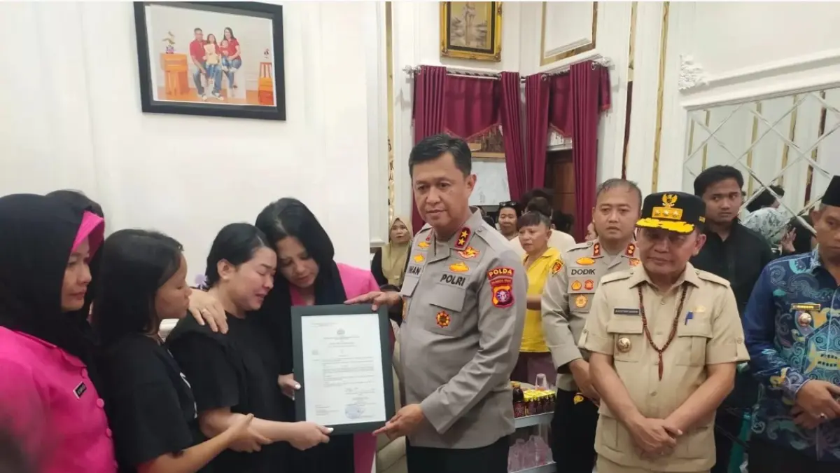 RAZIA NARKOBA BERDARAH: Kapolda Kalteng Irjen Pol Iwan Kurniawan saat menyematkan tanda kenaikan pangkat pada jenazah Aiptu (Anumerta) Yudhie Perdana Putra di rumah duka, Jumat (3/7). (JERI/KALTENG POS)