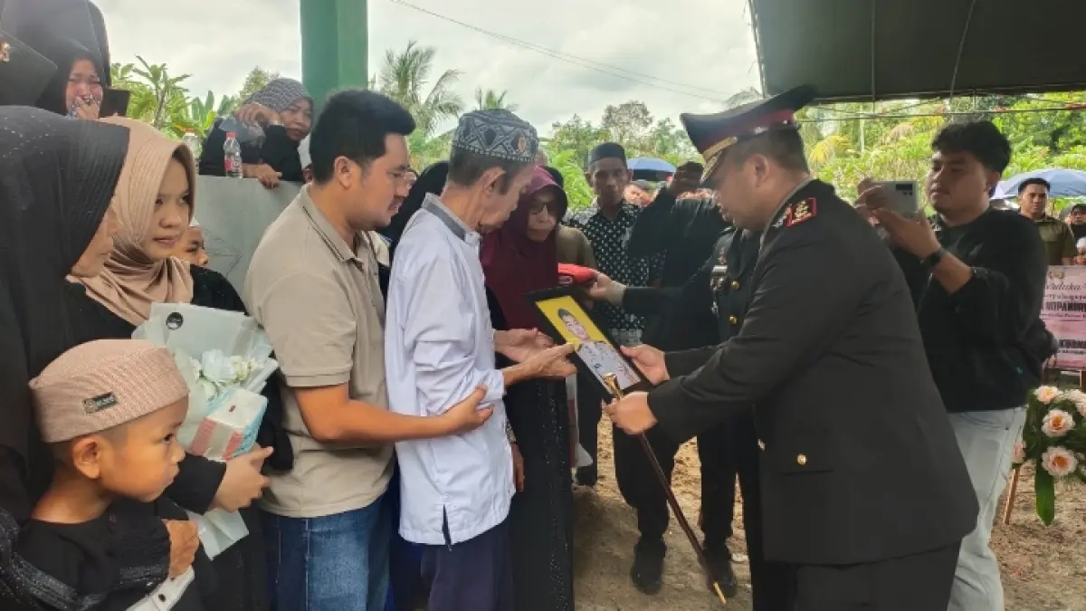 DALAM KENANGAN: Kapolres Katingan AKBP Dodik Hartono menyerahkan foto almarhum Briptu (Anumerta) Nopandri Ramadhana kepada perwakilan keluarga seusai pemakaman, Ahad (5/7). (JERI/KALTENG POS )
