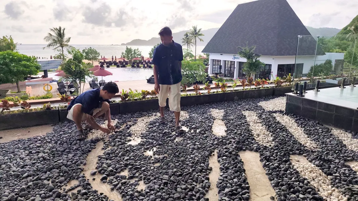 Dua orang karyawan sedang menata batu-batu hias menyerupai logo Pullman Lombok, beberapa waktu lalu. 