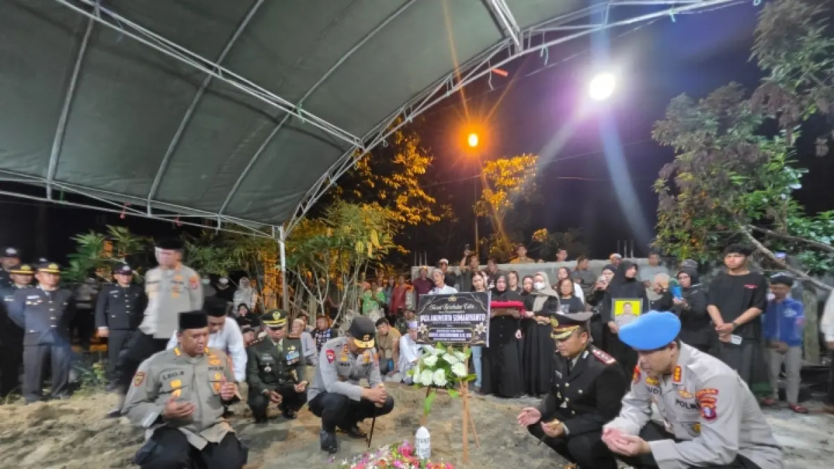 MELEPAS KEPERGIAN: Kapolda Kalteng Irjen Pol Iwan Kurniawan bersama jajaran berdoa di makam Ipda Anumerta Sumariyanto seusai pemakaman di Kasongan Minggu (5/7) malam. (JERI/KALTENG POS)