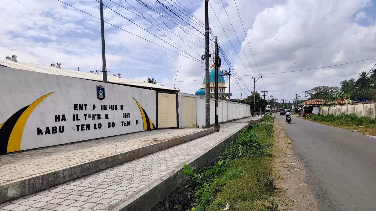 Sejumlah pengendara motor melintas di depan gedung Sentra Hasil Industri Tembakau (SIHT) Lombok Tengah di Desa Barabali, Batukliang, Senin (6/7). 