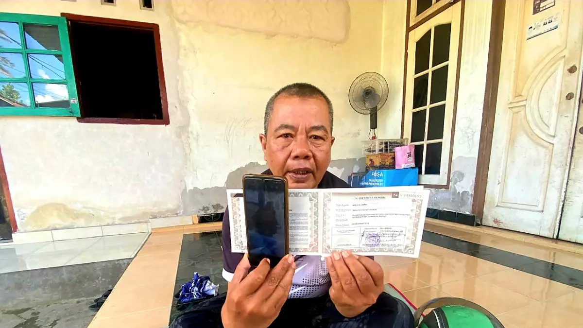 TUNJUKKAN BUKTI: Aliman, dirver ojek online asal Dusun Bilatepung Desa Beleka Lombok Barat menunjukkan bukti foto pelaku dan BPKB kendaraan miliknya yang dibawa kabur pelanggan. (Foto: Toni/Lombok Post)