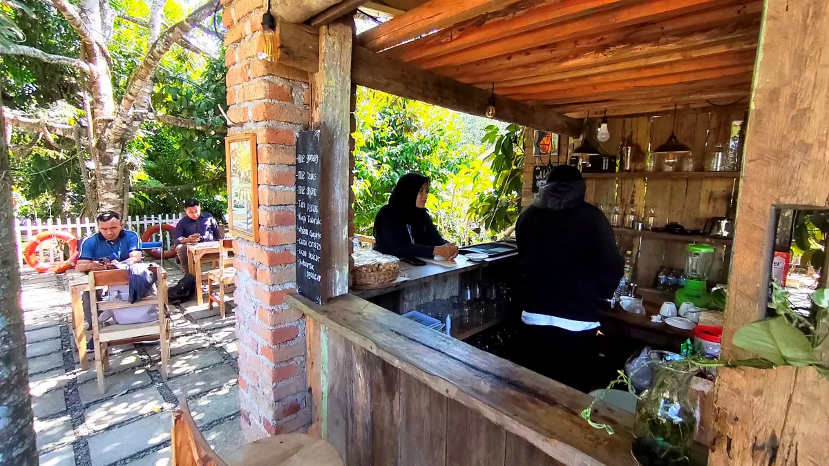 Sejumlah pengendara bermotor berhenti sejenak menikmati kopi dan cemilan yang disajikan Ahmad Zaelani di kedai kopi miliknya di jalan wisata Desa Aik Bukak, Desa Aik Bukak, Batukliang Utara, Lombok Tengah, Rabu (8/7).