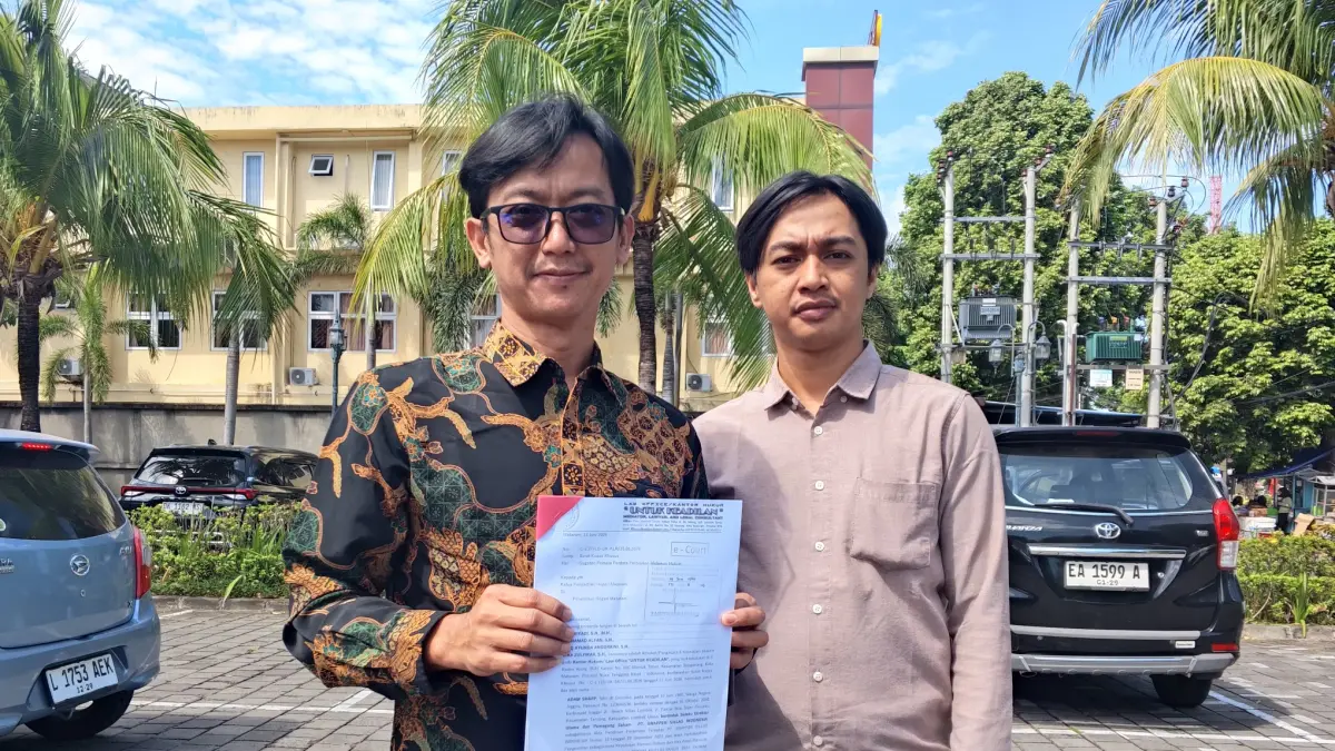 MENGGUGAT: Penasihat Hukum Adam Sharp, Riki Riyadi menunjukkan gugatan usai menjalani sidang yang ditunda di Pengadilan Negeri Mataram, Kamis (9/7) lalu. (HARLI/LOMBOK POST)