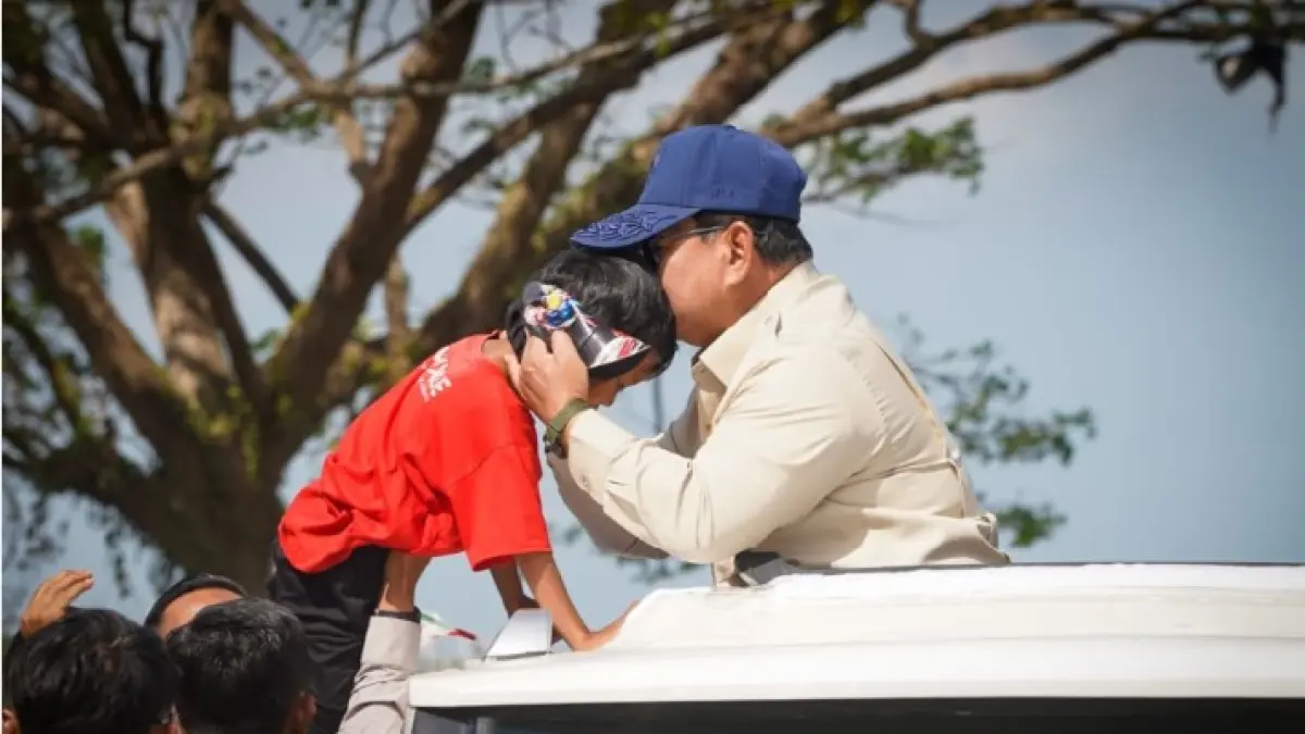 SAMBUTAN HANGAT: Presiden Prabowo mencium seorang anak yang menyambutnya saat kunker ke Provinsi NTB untuk meresmikan Bendungan Meninting di Kabupaten Lombok Barat, Jumat (10/7). (DISKOMINFOTIK NTB/LOMBOK POST)