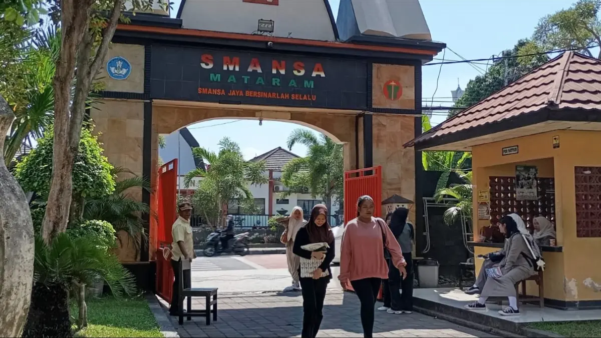SEKOLAH FAVORIT: Seorang wali murid mengantarkan anaknya mendaftar pada SPMB jenjang SMA di salah satu SMA Negeri tengah kota, belum lama ini.
 
