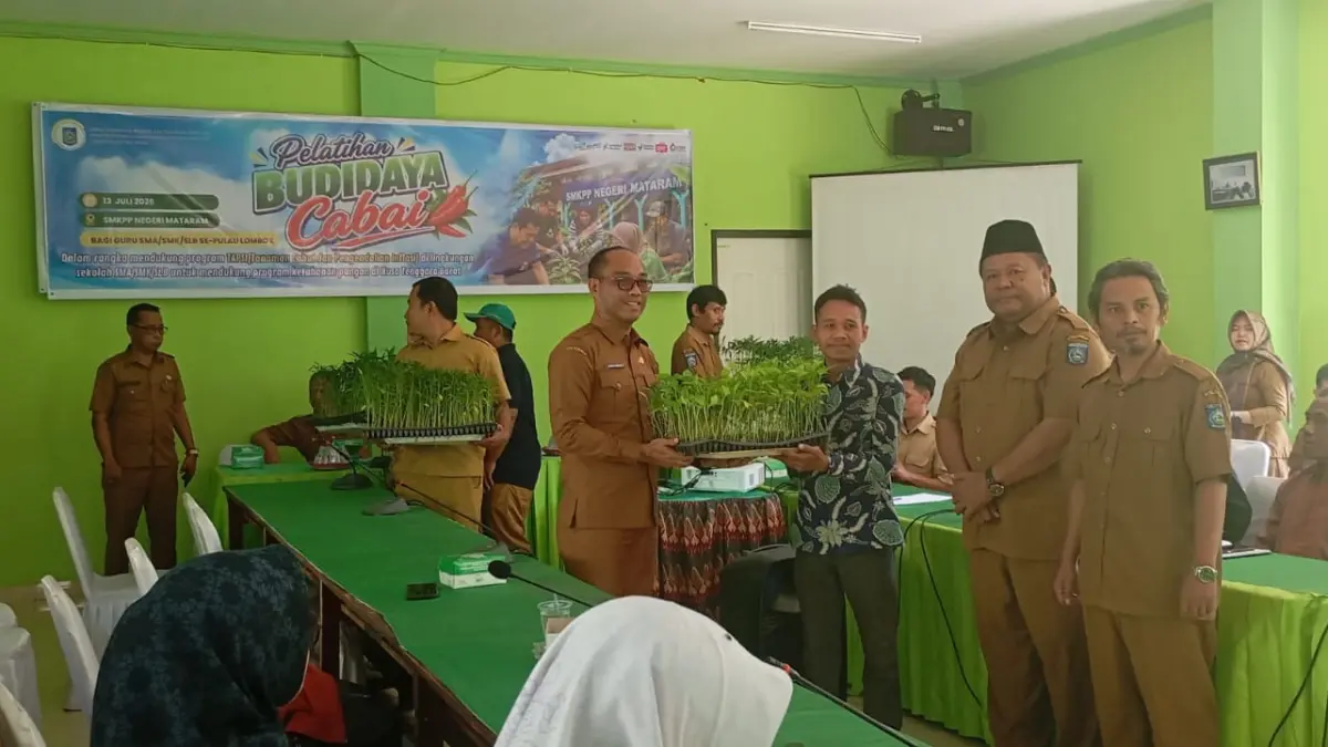 BUDI DAYA CABE: Kepala Dinas Pertanian dan Ketahanan Pangan NTB Lalu Mirza Amir Hamzah (pakai kacamata) menyerahkan bantuan bibit cabe kepada guru SMA/SMK/SLB di SMKPPN Mataram, Senin (13/7).