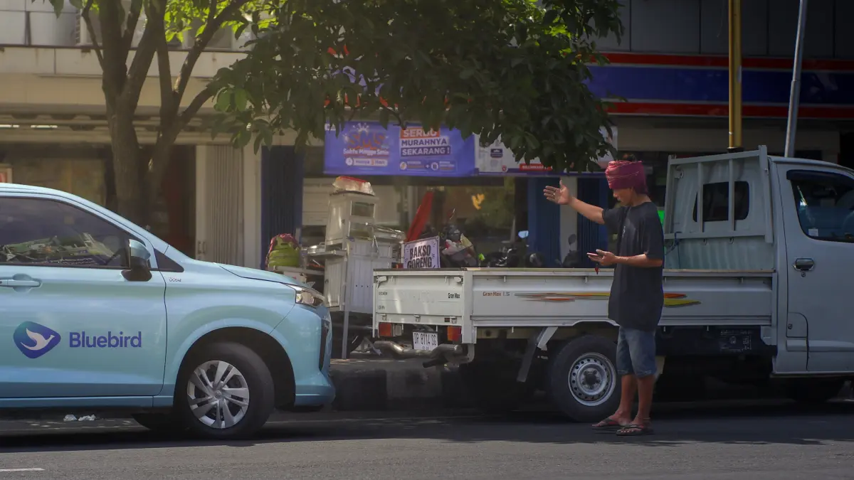 BUTUH PERLINDUNGAN: Salah satu juru parkir yang sedang mengatur parkir kendaraan roda empat di Kota Mataram, belum lama ini. (IVAN/LOMBOK POST)