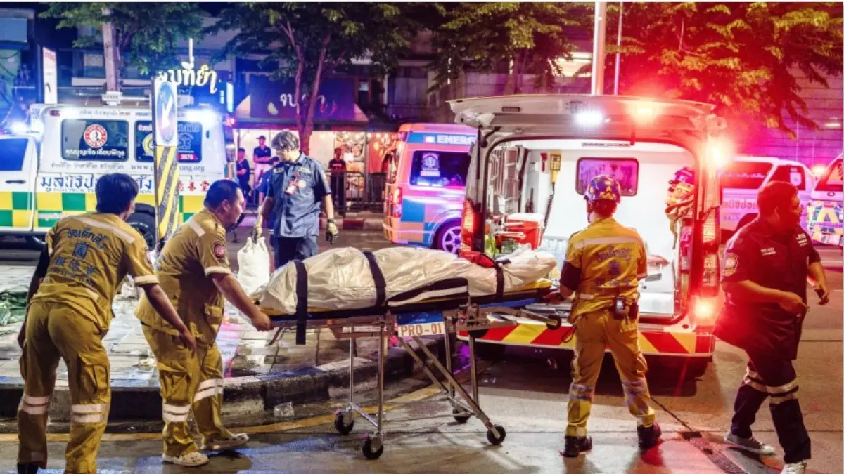 TAK SELAMAT: Petugas mengevakuasi korban kebakaran di Pub Rong Beer Na Lat Phrao di Bangkok, Thailand, Senin (13/7). (CHANAKARN LAOSARAKHAM/AFP)
