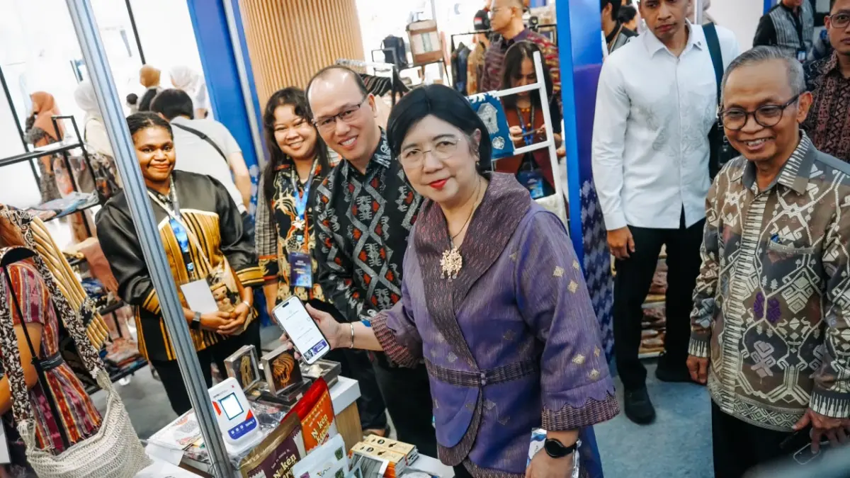 TRANSAKSI: Deputi Gubernur Senior Bank Indonesia Destry Damayanti (pegang ponsel) membayar produk ekonomi kreatif secara non tunai dalam event FESyar KTI 2026, di atrium LEM, Jumat (10/7). (BI NTB)