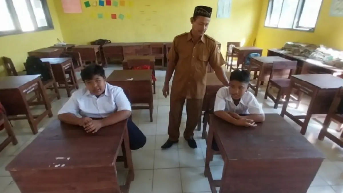 MINIM MURID BARU: Sisyono, guru SMPN 4 Tempurejo, Jember, bersama dua murid baru di kelas VII: Ferdiantoro (kiri) dan Fikri Agus Ramadhani. (JAWA POS)