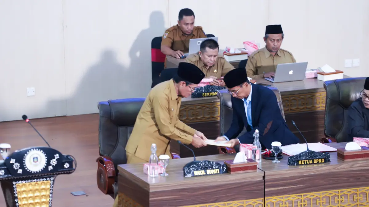 Wakil Bupati Loteng M Nursiah (kiri) menyerahkan berkas penjelasan kepala daerah tentang Rancangan KUA PPAS ABPD Loteng 2027 kepada Ketua DPRD Loteng Lalu Ramdan dalam sidang paripurna, Selasa (14/7).