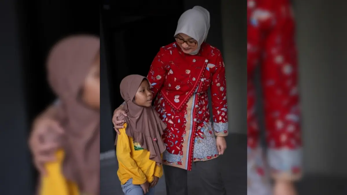 Hj Kinnastri Mohan Roliskana bercanda dengan seorang anak yang menjalani masa MPLS.  (IVAN/LOMBOK POST)