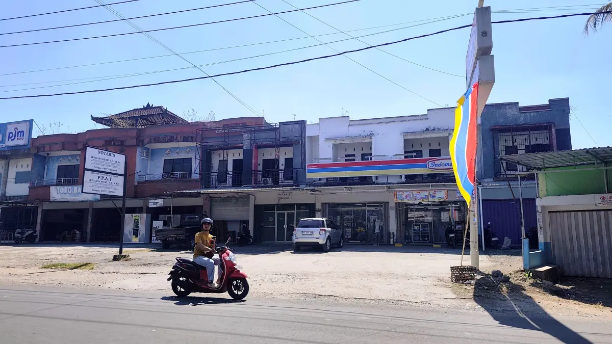 Pengendara motor melintas di depan gerai Indomaret yang kembali beroperasi dekat dengan Pasar Renteng, Praya, Loteng, Rabu (15/7).