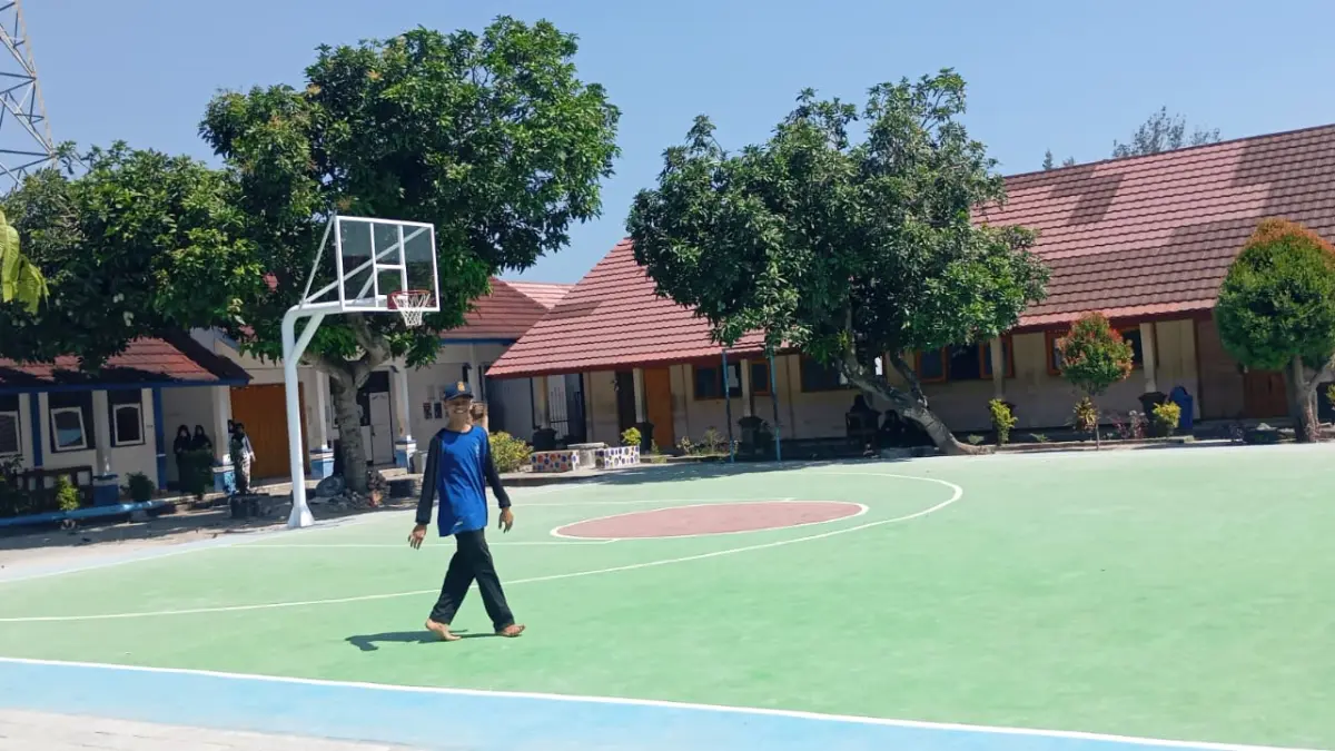 REPRESENTATIF: Seorang siswa SMPN 17 Mataram berjalan di lapangan basket sekolah setempat yang di PHO, Selasa (14/7).