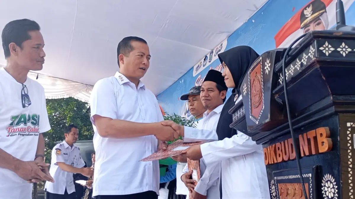 SIMBOLIS: Gubernur NTB Lalu Muhamad Iqbal didamping Kepala Dikpora NTb Syamsul Hadi memberikan insentif kepada PPPK paro waktu pada Gelar Karya SMK-SLB sekaligus peluncuran Program SMK Mendunia dan Gerakan Tanam Cabai dan Pengendalian Inflasi (Tapsi) di SMKN 5 Mataram, Rabu (15/7).