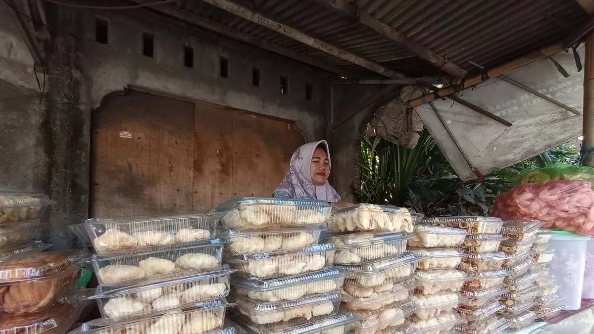 JAJAN TEMBERODOK: Salah seorang pedagang sekaligus pembuat jajan tradisional temberodok khas Desa Sakra sedang menunggu pembeli di pinggir jalan Raya Sakra-Keruak, Jumat (10/7).&nbsp;