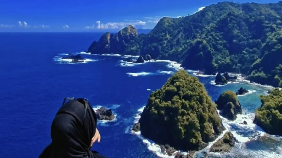 Pengunjung menikmati pemandangan birunya laut dan hijaunya bukit Pantai Orong Bukal, Sekotong, Lombok Barat. 
