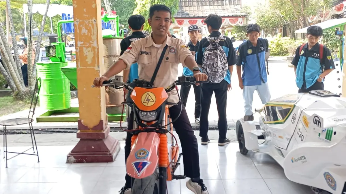MOTOR LISTRIK: Guru Teknik Energi Surya, Hidro, dan Angin SMKN 1 Lingsar Angga Eva Hari Saputra memamerkan motor listrik yang dirakit guru dan siswa pada Gelar Karya SMK-SLB sekaligus peluncuran Program SMK Mendunia dan Gerakan Tanam Cabai dan Pengendalian Inflasi (Tapsi) di SMKN 5 Mataram, Rabu lalu (15/7).

