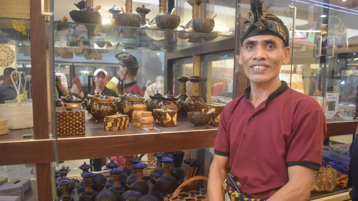 PRODUK UNIK: Lalu Surya Bakti menunjukkan produk kerajinan buatannya yang dipajang di etalase PLUT UMKM Lombok Tengah, beberapa waktu lalu. (DEWI/LOMBOK POST)