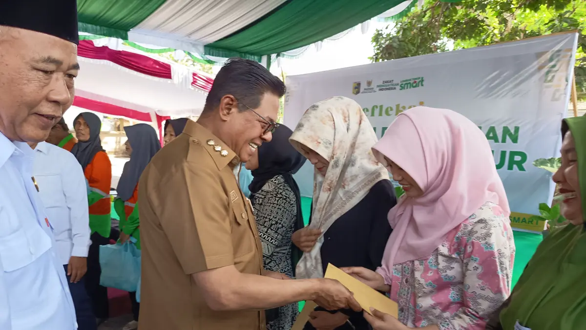 SERAHKAN BANTUAN: Bupati Lombok Timur (Lotim) Haerul Warisin didampingi Ketua Baznas Lotim Muhammad Kamli saat menyerahkan bantuan modal kepada sejumlah UMKM Lotim pada acara refleksi satu tahun pengabdian Baznas Lotim.
