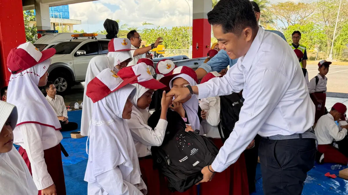 HARI ANAK NASIONAL: General Manager BIZAM Lombok Aidhil Philip Julian (kanan) secara simbolis memberikan bantuan tas sekolah kepada para siswa SDN 1 Tanak Awu, Rabu (22/7).