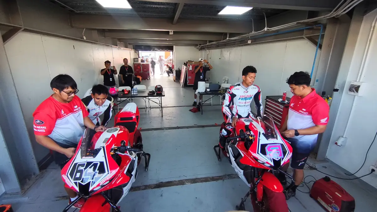 Pembalap Mario Aji (kiri) dan Veda Ega (kanan) tampak mempersiapkan kuda besi yang akan menggebrak lintasan Sirkuit Internasional Mandalika, Lombok Tengah, Selasa (21/7).