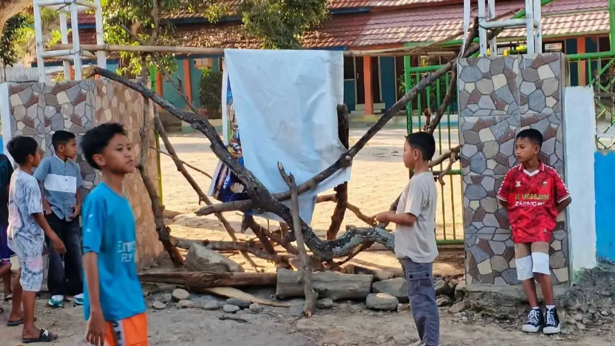 Siswa tampak berdiri di depan gerbang SDN Ragi karena sekolah mereka telah disegel, Kamis (23/7).