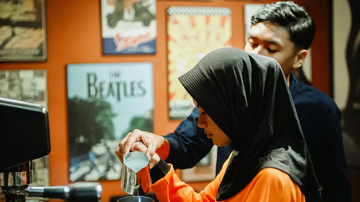 Salah satu siswi didampingi tim barista ESDA & Vescoff mempraktikkan keterampilan meracik minuman.