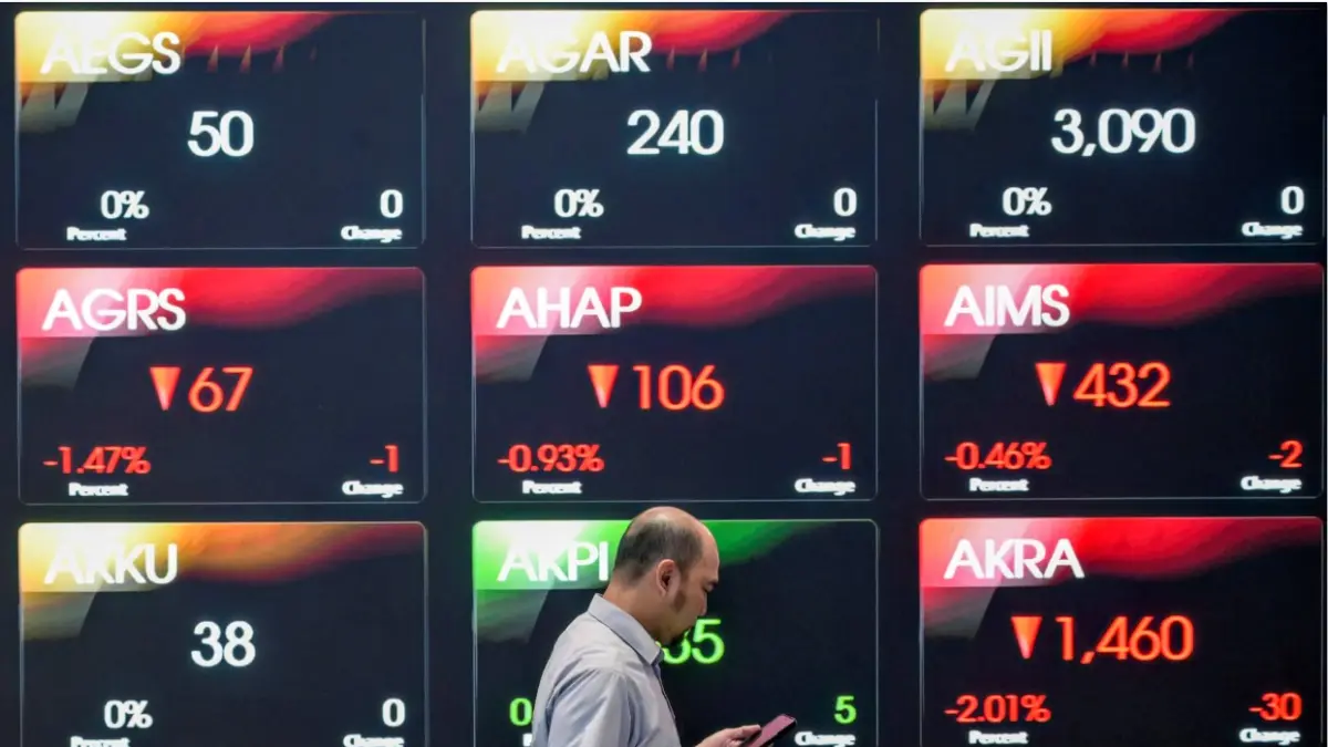 BURSA SAHAM: Seorang pria melintasi pergerakan saham yang menampilkan IHSG saat pembukaan pasar di gedung BEI di Jakarta beberapa waktu lalu. Pengamat menilai semester dua 2026 menjadi fase penguatan IHSG. (Jawa Pos)