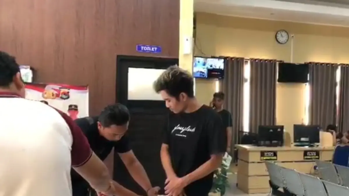 GELEDAH: Polisi menggeledah kantong celana JJ saat diamankan ke Mapolsek Selaparang, Sabtu (25/7). (HARLI/LOMBOK POST)

