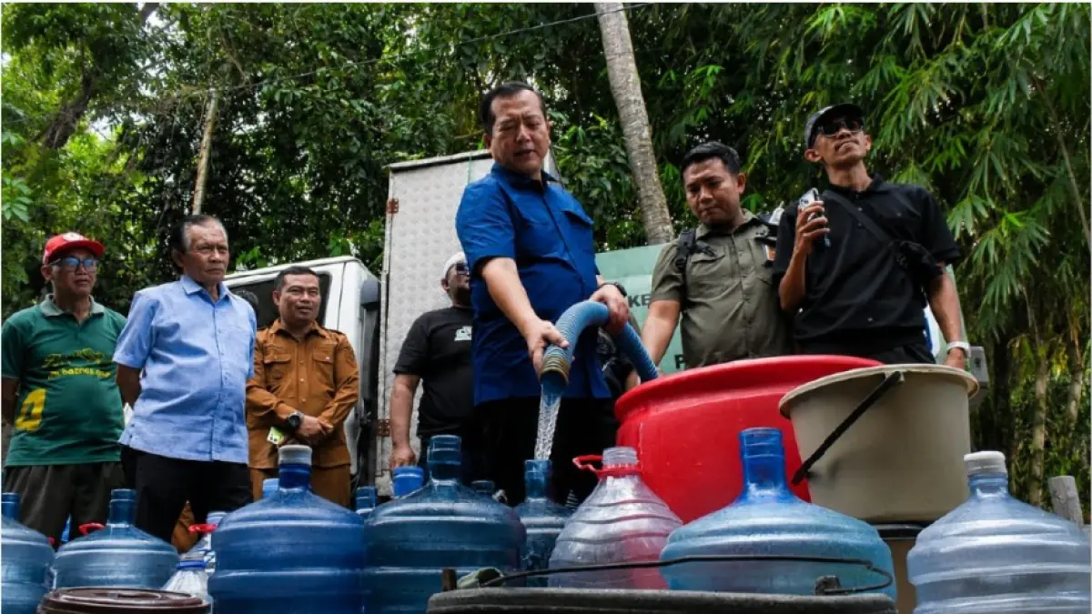 BANTUAN AIR: Gubernur NTB Lalu Muhamad Iqbal menuangkan air bersih ke sejumlah wadah yang disiapkan masyarakat saat kunjungan ke sejumlah desa di Lombok Tengah, Senin (27/7). (DISKOMINFOTIK NTB/LOMBOK POST)