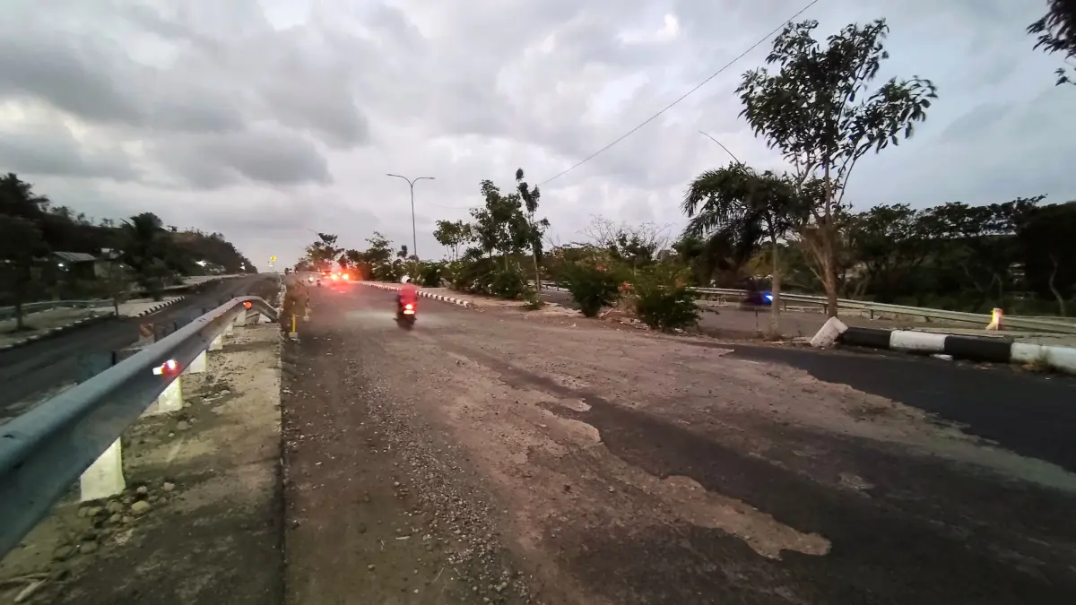 BONGKAR ULANG: Sejumlah pengendara bermotor saat melintasi ruas jalan nyaris amblas di jalan Bypass BIL-Mandalika, Loteng, Minggu (26/7).