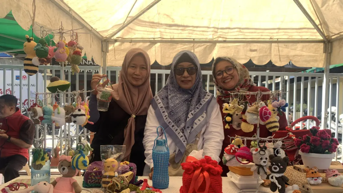Anggota Komunitas Sanggar Utas berpose di stan pameran dengan menampilkan ragam koleksi kerajinan rajut tangan