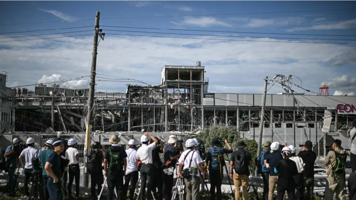 GEMPA: Para jurnalis berkumpul di luar Aeon Mall Kumamoto di Kashima, Prefektur Kumamoto yang rusak setelah gempa bumi melanda Jepang pada Rabu (29/7). (PHILIP FONG / AFP)
