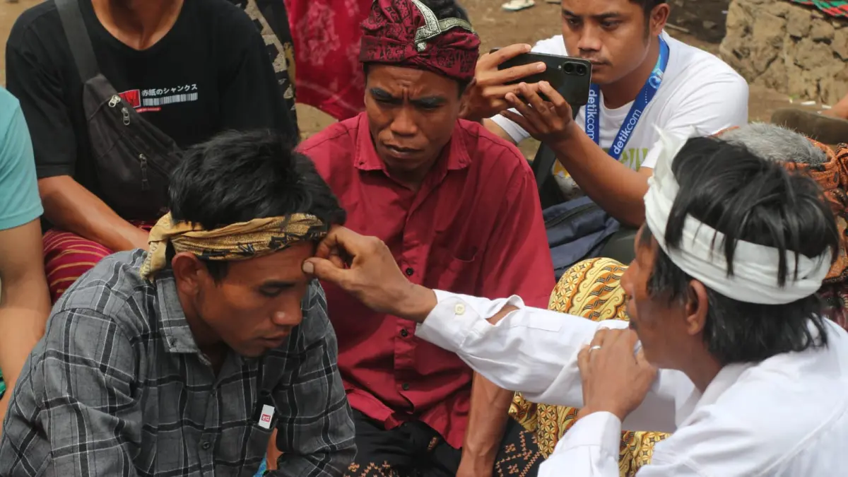 SEMBEK BURAK: Seorang tokoh adat di Desa Sajang, Kecamatan Sembalun saat melakukan ritual sembek kepada seorang warga yang akan naik ke gunung Rinjani pada saat acara ngasuh gunung belum lama ini