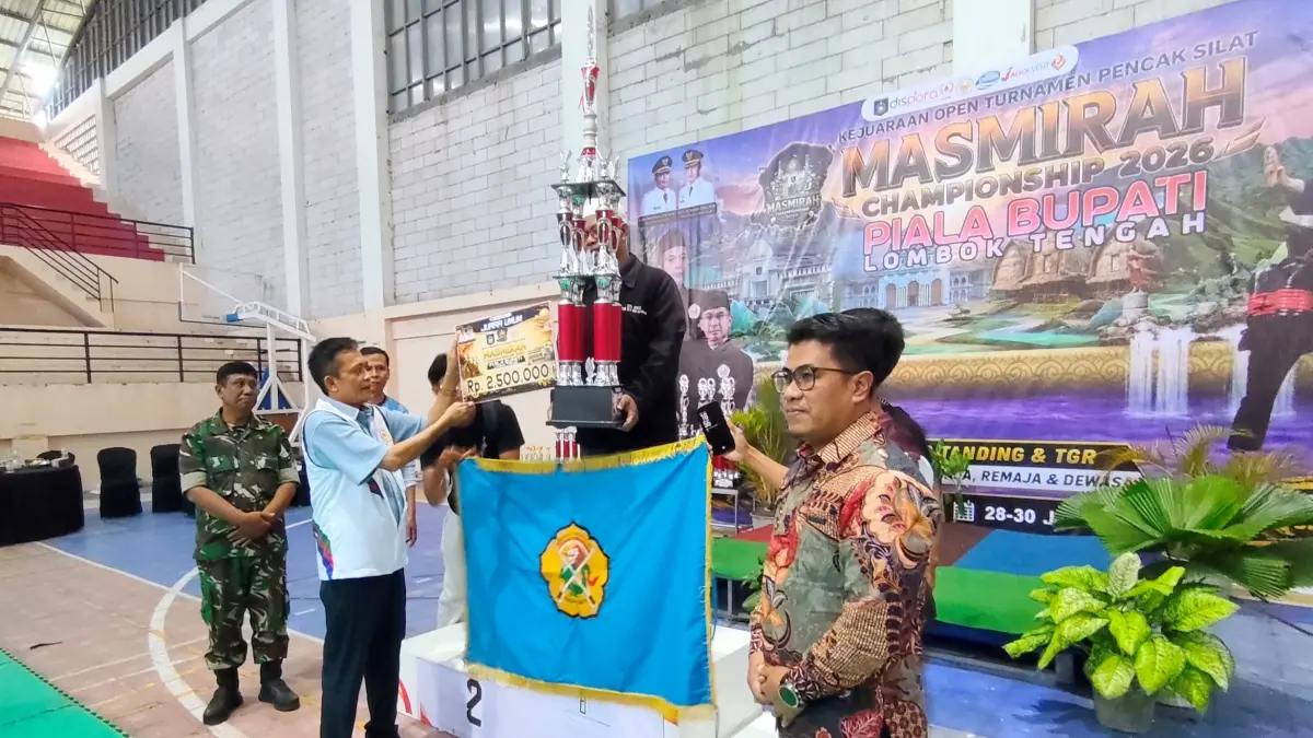 Bupati Loteng Lalu Pathul Bahri (dua kiri) menyerahkan piala Juara Umum Piala Bupati kepada pelatih Naga Sakti Lotim dalam ajang Kejuaraan Open Turnamen Pencak Silat Masmirah Championship 2626 Piala Bupati Lombok Tengah di GOR Tastura Praya, Kamis (30/7).