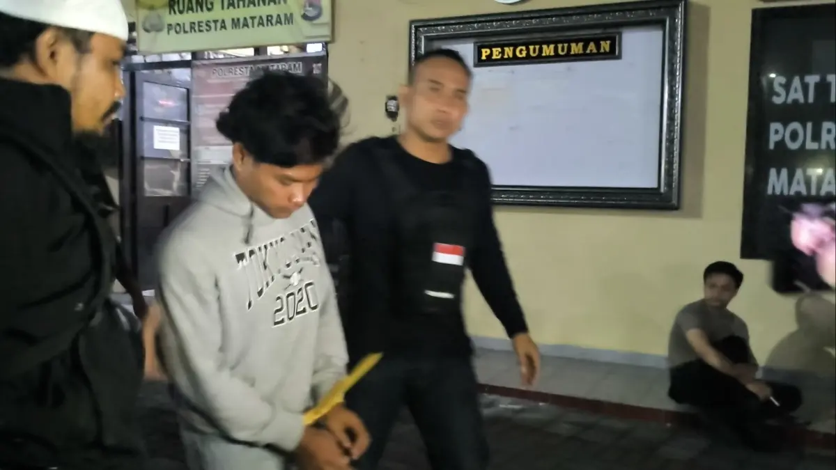 DITAHAN: Tersangka Haikal Putra digiring anggota Satreskrim Polresta Mataram usai ditangkap, Rabu malam (29/7). (HARLI/LOMBOK POST)


