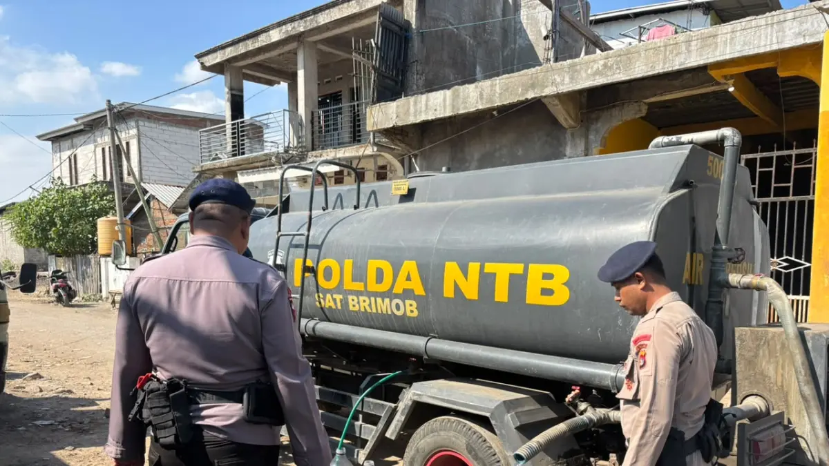 MERINGANKAN BEBAN WARGA: Tim personel Brimob Polda NTB salurkan air bersih ke wilayah terdampak kemarau di Kota Bima, Kamis (30/7). (POLDA NTB FOR LOMBOK POST) 